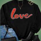 Black sweatshirt with 'love' in red and rhinestone outline, paired with blue jeans and black boots on a green background.