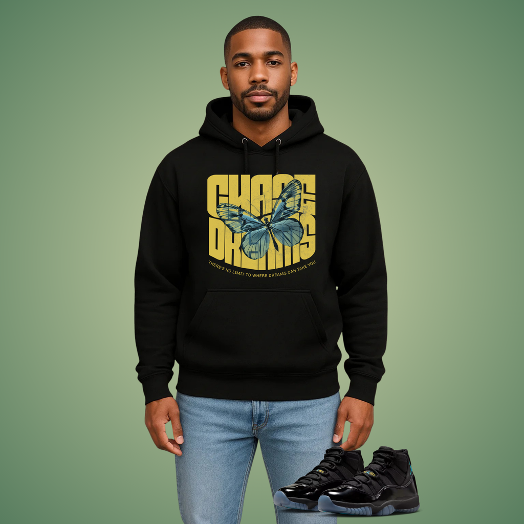 Man wearing a black hoodie with a butterfly graphic and text, Chase Dreams, on a green background
